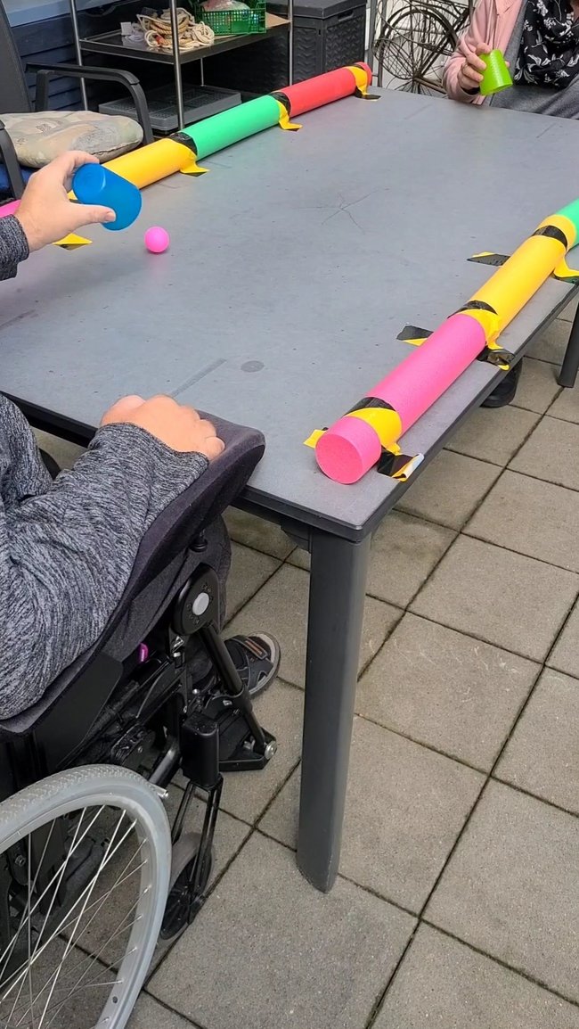 Der Tischtennisball wurde mit einem Becher einander zugespielt und gefangen.