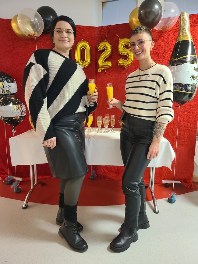 Petra Andrießen (links) und Birte Wind stoßen beim Neujahrsempfang mit Sekt an.