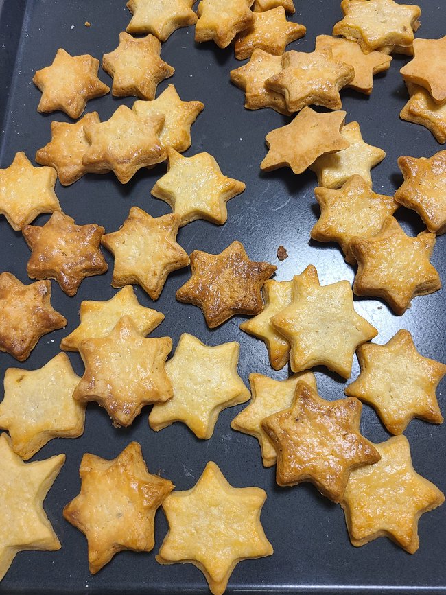 Fertig gebackene Sternplätzchen auf Backblech.