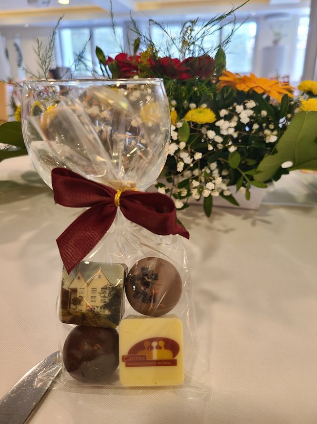 Pralinengeschenk für Bewohner mit einem Bild der Einrichtung sowie dem Logo.