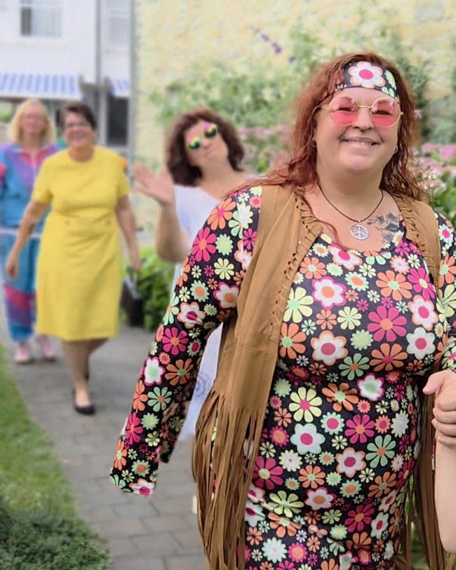 Die Modenschau des Sozialen Dienstes: zu sehen im Vordergrund ein Hippie-Damen-Outfit. Die anderen Models sind im Hintergrund verschwommen.