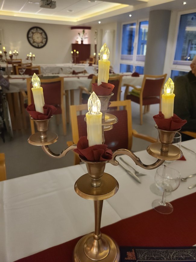 Kerzenständer mit LED-Kerzen und ein festlich gedeckter Tisch.