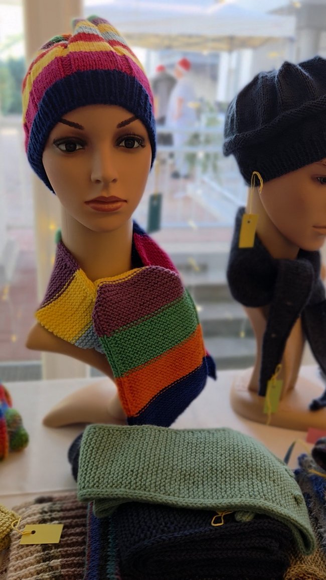 Ausgestellte Strickware, Mützen, Schals auf dem Adventsbasar.