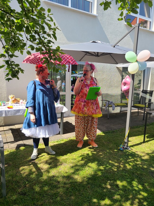 Humorbotschafterinnen Mia Mumpitz und Blümchen verteilen die Losgewinne.