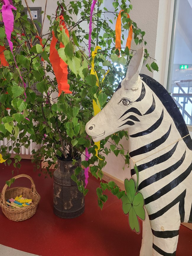 Der Maibaum mit dem St. Antonius Zebra vor der Cafeteria.