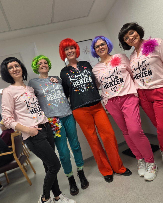 Die Mitarbeiterinnen der Tagespflege präsentieren im Team ihre Konfetti-Kostüme.